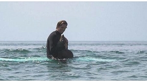 Illustration : "Un surfeur se retrouve avec un ami inattendu sur sa planche au détour d'une vague...De quoi être jaloux !"